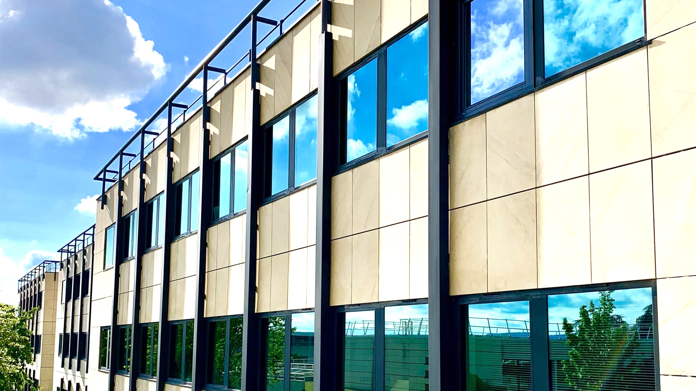 Façade tertiaire en pierre et baies vitrées, nettoyée et entretenue par TLN